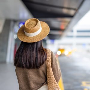 Travel woman wait for the bus outside airport Travel woman wait for the bus outside airport